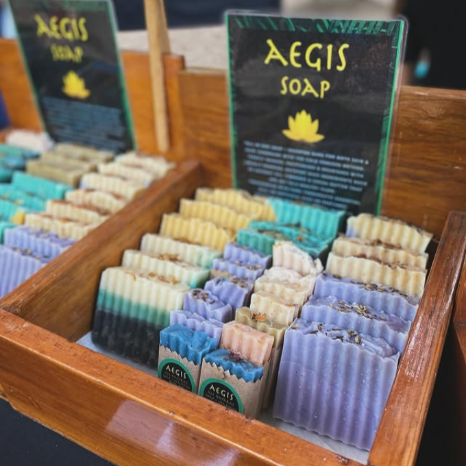 Display of Aegis Soap bars in a wooden box with branded cards.