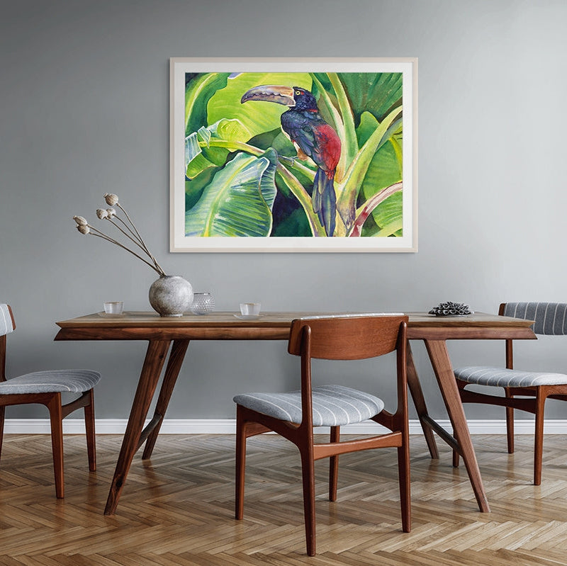 Dining room with wooden table and chairs, and a colorful toucan painting on the wall.