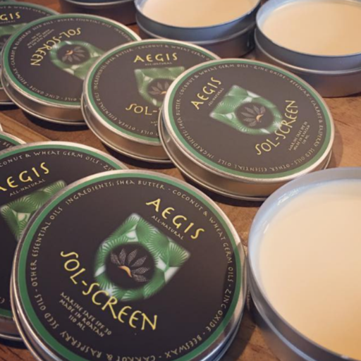 Multiple tins of Aegis Sol-Screen on a wooden surface