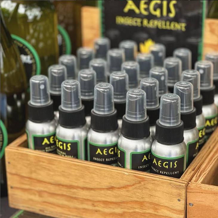 Aegis insect repellent bottles in a wooden crate with visible branding.