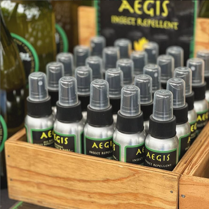 Aegis insect repellent bottles in a wooden crate with visible branding.