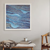 Framed abstract artwork on a wall above a bench with decorative items.