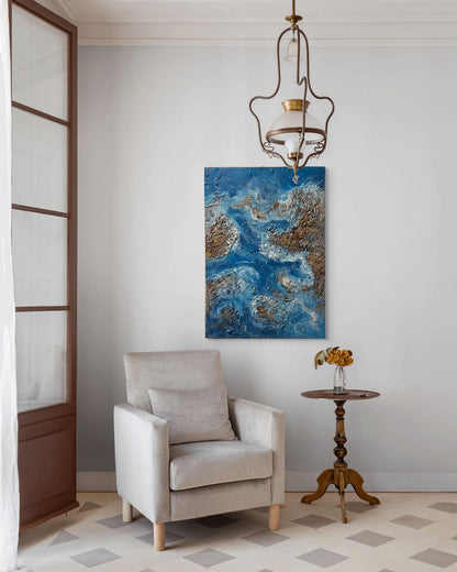 Living room with a beige armchair, abstract blue painting, and wooden side table.